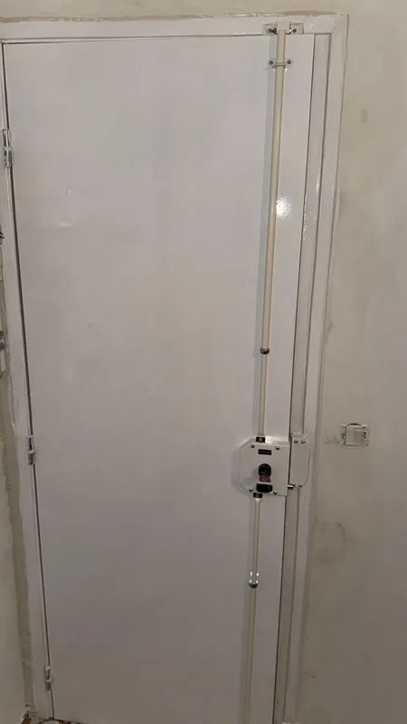 Serrure multipoints à tringles sur porte d'entrée blanche